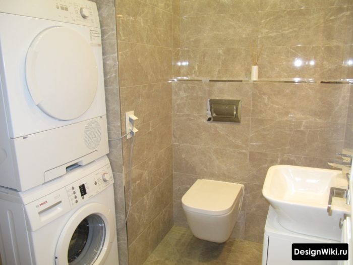 Сушильная машина находится на стиральной машине в ванной комнате