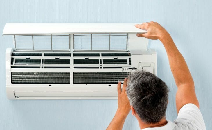 Мужчина устанавливает сплит-систему Haier Мужчина устанавливает сплит-систему Haier